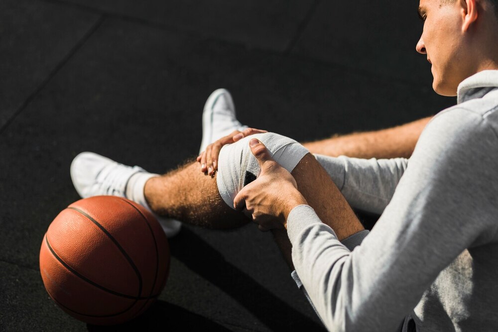 jugador baloncesto aplicando vendaje rodilla