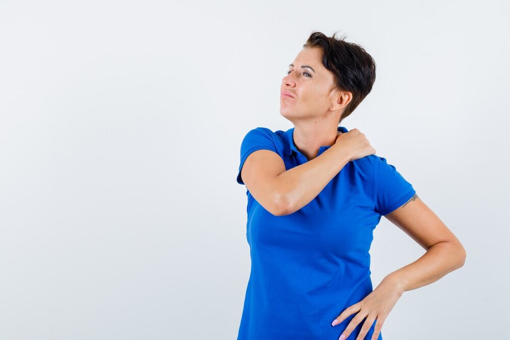 mujer madura que sufre dolor hombro camiseta azul